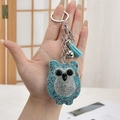 Sparkling crystal owl keychain with light blue tassels and rhinestones held by hand - Keychain + Owl / Multicolor Sky Blue