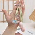 Portachiavi a cuore liquido verde con orsetto e ciondoli a forma di tulipano rosa - Boccetta di profumo