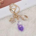 Golden ocean keychain with purple resin conch, starfish and shell charms on white fur - Purple