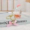 Detalle de un llavero líquido rosa con una ballena beluga y dije de corazón dorado - Delfín Rosa
