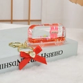 Detail of pink cartoon rabbit charm in orange liquid glitter bus with red bow keychain - Red