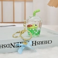 Llavero de taza de té con leche con tortuga flotante y lazo azul sobre felpa blanca - Pequeña Tortuga Verde