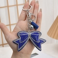 Blauwe strass strik sleutelhanger met zilveren kwastjes en metalen belletje - Koningsblauw