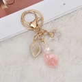 Golden starfish and conch keychain with pink gradient shell charm on plush background - Pink