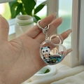 Detail van de hartvormige panda sleutelhanger met blauw glitterzand en een donut - Hartslot Panda Stijl