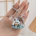 Detail van de schattige panda hoofd vloeibare drijfzand sleutelhanger met blauwe lovertjes - Berenkop Panda Stijl