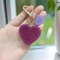 Sparkling rose red rhinestone heart keychain with gold spring ring held in hand - Purple Fuchsia