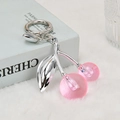 Portachiavi creativo con ciliegie in resina rosa e foglie argentate su fondo morbido - Rosa