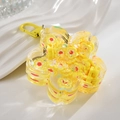 Dettaglio del portachiavi in acrilico a fiore con paillettes gialle e fibbia - Giallo Limone