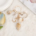 Golden starfish and conch seashell keychain with large lobster clasp on white plush - Alloy Electroplated Ocean Pendant (2)