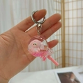 Close-up of pink rabbit acrylic keychain with liquid glitter and lollipop design - Pink Lollipop Style