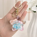 Close-up of star shaped liquid quicksand keychain with blue fish floating in acrylic case - Blue