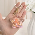 Close-up of star-shaped acrylic keychain with floating fish and colorful glitter - Lemon Yellow