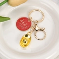 Gelukssleutelhanger met rood emaille label en goudkleurige bedel voor goede wensen - Goede dingen gebeuren