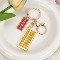 Goldener Abakus Schlüsselanhänger mit rotem Anhänger in einer weißen Schale - Akademischer Erfolg (Goldverschluss + Abakus)