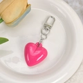 Pink heart-shaped keychain pendant with silver metal clip on a white plate with tulips - Bright Pink Resin 3D Heart