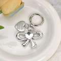 Elegant silver metallic bow and heart keychain displayed on a white ceramic tray - Silver Bow Heart with Engraved Tag