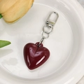 Close-up of deep red heart keychain with mirror finish and silver lobster clasp - Red Mirror Resin Heart