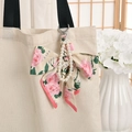 Floral silk bow and pearl chain charm with pink mini bag hanging on a canvas tote - Pink