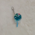 Close-up of blue lollipop acrylic keychain with glitter star filling on white fur background - Lollipop Shape - Gate Buckle Style
