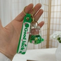 Detail eines grünen Hasen-Schlüsselanhängers mit Good Luck-Band und goldener Schließe - Grünes Einhorn