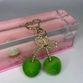 Macro detail of green flocked cherry pendant with golden bow and heart-shaped keychain - Heart Buckle - Green Flocked