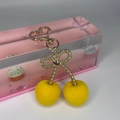 Close-up of yellow flocked cherry pendant with golden bow and heart-shaped lobster clasp - Heart Buckle - Yellow Flocked
