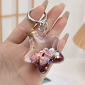 Sternförmiger Acryl-Schlüsselanhänger mit rosa Muscheln und glitzernden Elementen im Inneren - Silberner Ring Rot