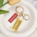 Détail du mini boulier doré et breloque en émail rouge avec texte Good Luck sur porte-clés - Bonne chance