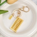 Vue détaillée de deux pendentifs boulier dorés avec porte-clés et fermoir homard - Double boulier