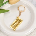 Vue détaillée d'un porte-clés boulier doré sur une assiette blanche avec décoration - Boulier
