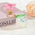 Détail d'un porte-clés fruit avec paillettes colorées, strass roses et anneau doré - Style Dragonne en Strass Blanc