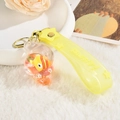 Detail of creative shell liquid keychain with floating fish, sequins, and yellow silicone strap - Lemon Yellow Clownfish