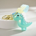 Macro shot of gradient luminous dinosaur keychain with a blue aurora finish and gold ring - Light Blue