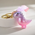 Dettaglio portachiavi a dinosauro luminoso con finitura laser e cinturino in silicone viola - Rosa Viola