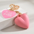 Macro shot of pink double-heart charms with FOR EVER engraving and gold hardware - Pink