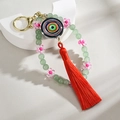 Handmade beaded evil eye keychain with blue beads, colorful circular charm and red tassel - Dark Green