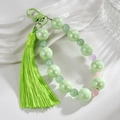 Detail of fresh green beaded keychain with silk tassel and iridescent round beads - Fruit Green