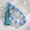 Detail of blue iridescent beaded keychain with smooth silk tassel and glossy lacquer clasp - Blue