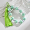 Detail of mint green beaded keychain with iridescent pearls and a soft silk tassel - Light Green