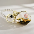 Macro view of cloud-shaped liquid oil keychain with cute pig and pearl bead strap - Cloud