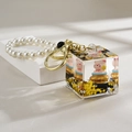 Detail of pink pig doll inside acrylic glitter cube with elegant pearl wrist strap - Square Bottle