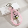Pink beaded keychain with cherry blossom tree pendant and butterfly design on white stand - Pink