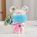 Pink bear liquid keychain with blue fluid and colorful beads on a white pedestal - Blue Bear
