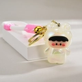 Detailed view of luminous frog baby keychain with pink braided strap and golden bell - White