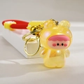 Detail of yellow translucent glowing frog keychain with gold bell and colorful strap - Lemon Yellow