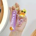 Détail du porte-clés canard jaune avec bouteille liquide violette et bracelet silicone - Tasse de Thé au Lait Violette