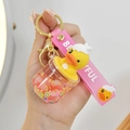 Détail d'un porte-clés canard mignon avec sable mouvant liquide et bracelet rose pour sac - Grande Tasse Ventre Rose Rouge