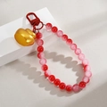 Red gradient beaded keychain with golden ingot charm on a modern white display - Gold Ingot