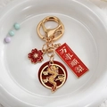 Détail du porte-clés dragon chinois avec relief doré et pendentifs porte-bonheur - Style Tout Va Bien